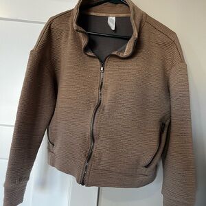 RBX zip up for women. Size M. Beige in color with side zipper pockets.